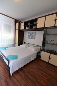 a bedroom with a large white bed and cabinets at Apartment Nevena in Mali Lošinj