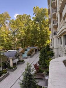a courtyard of a building with a bench and trees at Apartment prime residence in Ak-Tyube