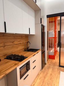 a kitchen with white cabinets and a stove top oven at Apartment prime residence in Ak-Tyube