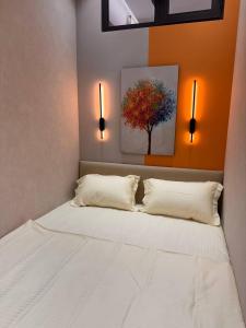 a bedroom with a bed with two pillows and a tree at Apartment prime residence in Ak-Tyube