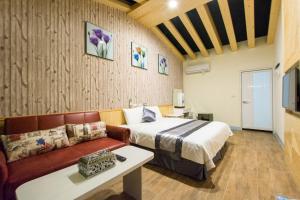 a hotel room with a bed and a couch at Melinda Resort in Hengchun +60 photos