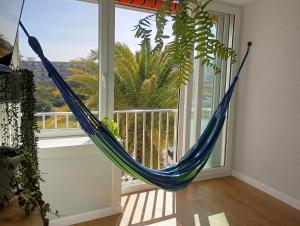a hammock hanging in a room with a window at La Pineda Pisito Playero in La Pineda