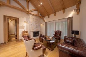a living room with leather furniture and a fireplace at Evergreen Forest Retreat Zhangjiajie, Near National Forest Park Avator Park, Luxury Nature Escape, Free Airport&Train Shuttle Service & Travel itinerary, English Speaking Butler in Zhangjiajie