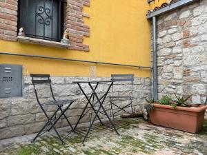 two chairs and a table in front of a building at Dimora San Mercurio 100 in Campobasso