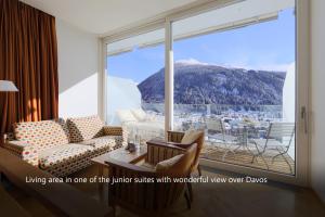 Waldhotel & SPA Davos - for body & soul في دافوس: غرفة معيشة مطلة على جبل