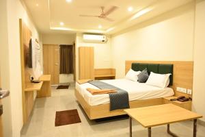 a hotel room with a bed and a table at Hotel Sree Kanya Inn in Visakhapatnam +31 photos