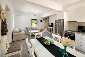 a kitchen and living room with a table and chairs at Elaion Serenity in Lákka