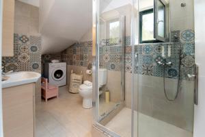 a bathroom with a shower and a toilet and a sink at Elaion Serenity in Lákka +7 photos
