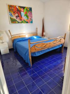 a bedroom with a bed and a blue tiled floor at La casita in Capo Vaticano