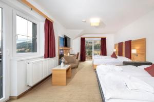 ein Hotelzimmer mit zwei Betten und einem Fenster in der Unterkunft Hotel Sonnschupfer in Schladming + 76 Fotos