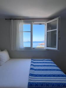 a bedroom with a bed and a window with a view at Kimoliatiko in Kimolos