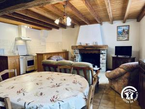 a living room with a table and a fireplace at Le gîte de cals haut in Lacombe +14 photos