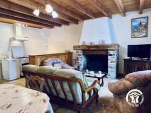 a living room with a couch and a fireplace at Le gîte de cals haut in Lacombe