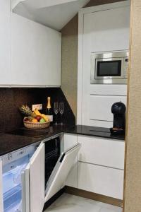 a kitchen with white cabinets and a microwave at Las Americas Prime Suite Spot in Costa de Adeje