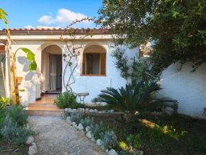 a white house with a staircase leading to a window at La casita in Capo Vaticano