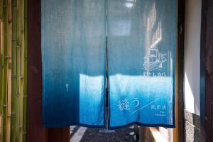 a window with blue curtains with a boat on it at Nuu Takedamise, the Villa in Kami-yuge +24 photos