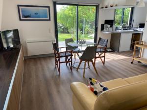 a living room with a couch and a table and chairs at Hameau de la Brelaudière in Jullouville-les-Pins