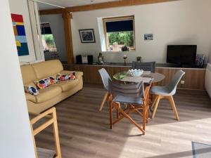 a living room with a couch and a table and chairs at Hameau de la Brelaudière in Jullouville-les-Pins