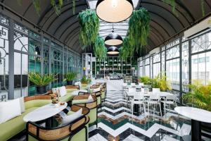 a restaurant with tables and chairs and plants at S31 Sukhumvit Hotel in Bangkok