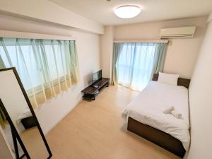 a bedroom with a bed and a mirror and a television at Chateau Sunrise in Tokyo