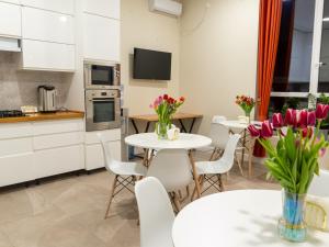 a kitchen and dining room with tables and flowers at Fresh hostel in Almaty
