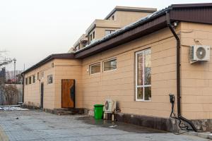 aige brick building with a door and a fan at Fresh hostel in Almaty