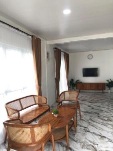 a living room with a wooden table and chairs at The Kaluna Resort in Lamno