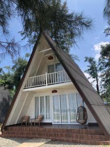 a house with a triangular roof with a porch at The Kaluna Resort in Lamno
