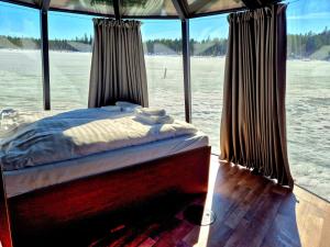a bed on the back of a boat with windows at Aurora Camp Kiruna in Kiruna