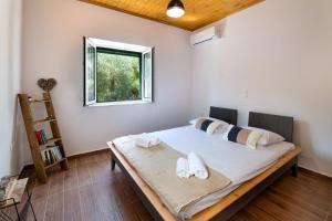 a bedroom with a bed with two towels on it at Elaion Serenity in Lákka