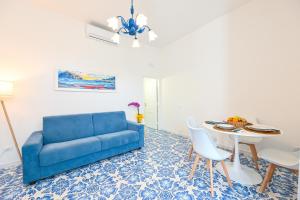 a living room with a blue couch and a table at La Casa del Mozzo in Ischia