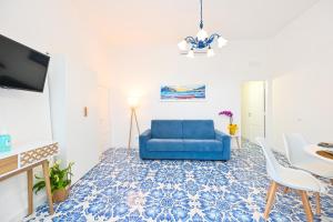 a living room with a blue couch and a table at La Casa del Mozzo in Ischia
