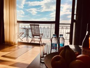 a table with a bowl of fruit and water bottles on a balcony at Студиа При Американеца in Pomorie +18 photos