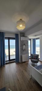 a living room with blue curtains and a chandelier at Bluemarina Apartamente in Mamaia