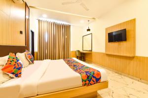 a hotel room with a bed and a flat screen tv at FabHotel Madhuban in Jaipur