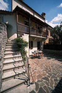 a building with stairs and a balcony with a table at Casa Valerija in Aurisina
