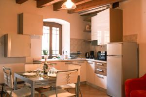 a kitchen with a table and chairs and a refrigerator at Casa Valerija in Aurisina