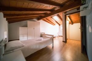 a bedroom with a white bed and wooden ceilings at Casa Valerija in Aurisina
