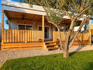 a house with a wooden fence and a tree at Aurea Lux in Pakoštane