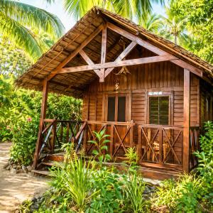 a small wooden cabin with a thatched roof at Le Moya Beach in Nosy Be