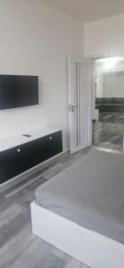 a white room with a bed and a tv at Ysa home in Râmnicu Vâlcea