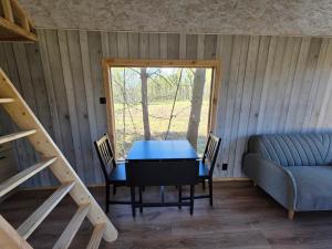 a room with a table and a couch and a window at Domek POD LASEM in Białowieża