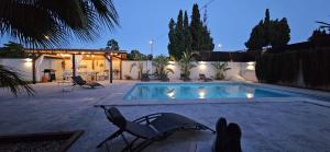 a swimming pool with two chairs next to a house at Villa Alicante Sunbeach in El Campello