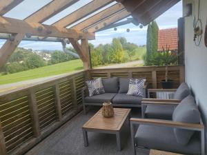 a patio with couches and a table on a deck at Ferienwohnung Landliebe in Reichertsried