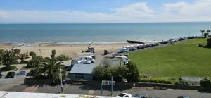 a parking lot next to a beach with cars parked at Oban Hotel in Eastbourne
