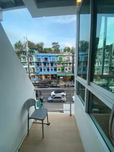 a chair sitting on a balcony with a view of a street at SR Phuket in Patong Beach