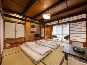 a room with two beds in it with a table at Yamaga Onsen Sumi in Yamaga +22 photos