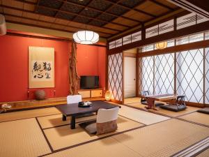 a living room with red walls and a table and chairs at Yamaga Onsen Sumi in Yamaga