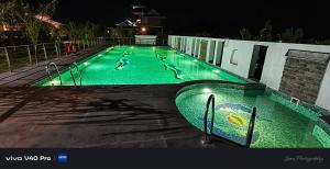 a swimming pool at night with ducks in it at Resort Bihanga in Chālsa Mahābāri