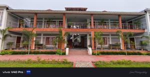 a large building with a balcony on the front of it at Resort Bihanga in Chālsa Mahābāri